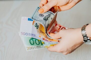 Человек держит в руках доллары, евро