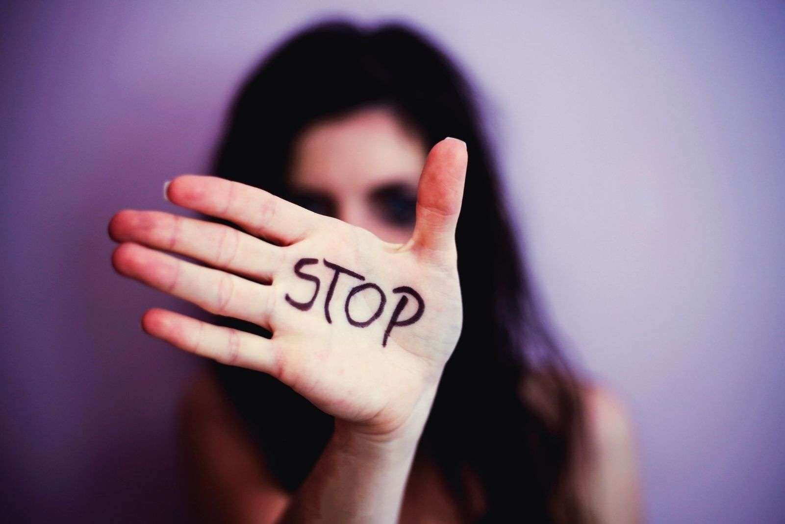 Женщина с выставленной вперёд ладонью с надписью Stop - меры защиты женщин от насилия