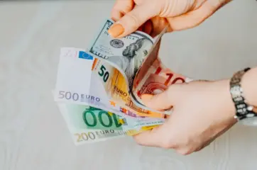 доллары и евро в руках человека